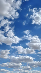 Obraz premium Bright blue sky filled with fluffy white clouds on a sunny day, creating a peaceful and uplifting natural scene. 