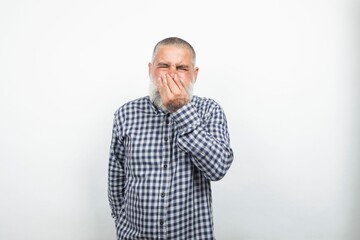 Senior man covering nose because of bad smell on white background