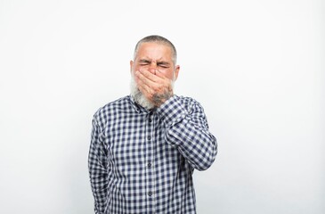 Mature man covering his mouth showing disgust or holding back laughter