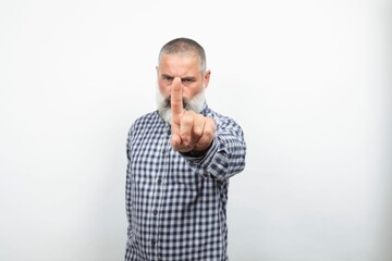 Serious senior man making stop sign with index finger