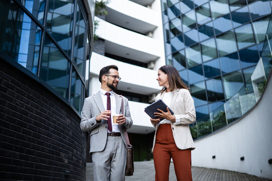 Business people walking and talking outside office building