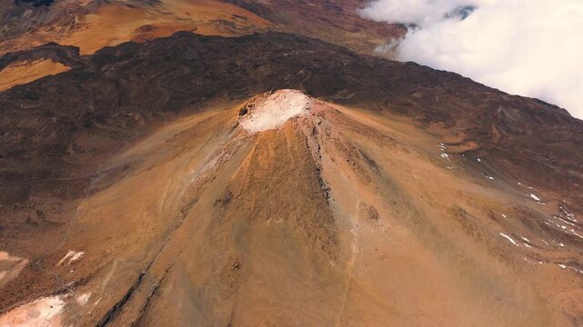 Aerial approach to the summit of Mount Teide with crater slowly revealed in center of frame at sunset, Teide National Park, Tenerife