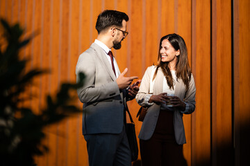 Business partners discussing during coffee break outside office building