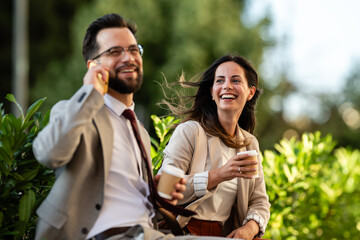 Business people talking and smiling during coffee break outdoors
