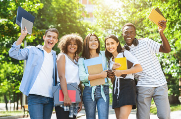 Students Community. Group Of College Friends Posing For Group Photo Outdoors, Holding Workbooks In...