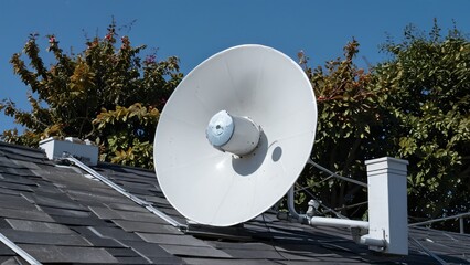 Satellite Dish on Building Rooftop Against Blue Sky