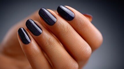 Close Up Of Woman's Hand With Dark Blue And Gold Glitter Nails