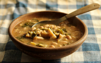 A photograph of a rustic clay bowl filled with "Sorve (Sopa de Bolo)" – a hearty Angolan soup.