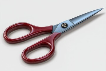 A pair of sharp metal scissors with glossy red handles isolated on white background for crafting or office use