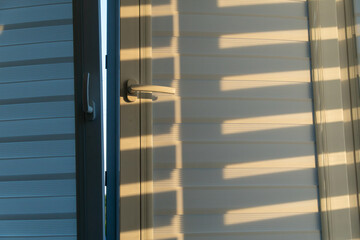 A door slightly ajar allows sunlight to create interesting shadow patterns on the wall. The soft...