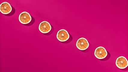 Vibrant Pink Background with Diagonal Line of Dried Orange Slices: Minimalist, Summery, and Refreshing Design.