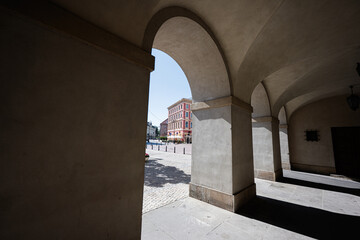 Arched passageway shadows framing colorful building in Warsaw, Poland cityscape