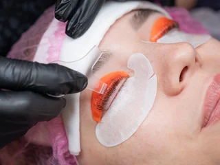Gordijnen Caucasian woman undergoing eyelash lamination procedure.  © Михаил Решетников
