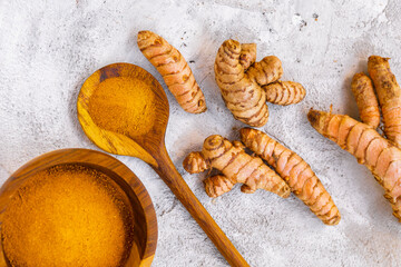 Fresh and Ground Turmeric on Rustic Background – Natural Health and Culinary Ingredient