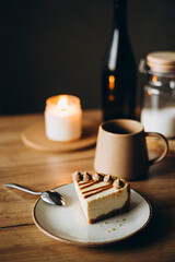 Piece of cheesecake with caramel topping on ceramic plate on wooden table.