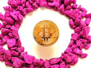 Golden bit coin floating in pink stone circle on white background. Finance and online currency...