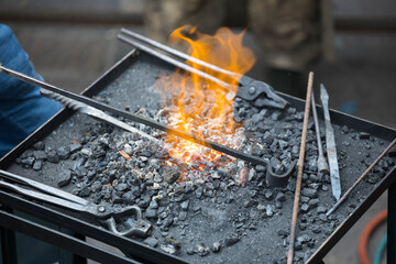 Blacksmithing forge with tools and hot coals in workshop