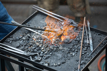 Blacksmithing craft: forging iron in intense flames with tools