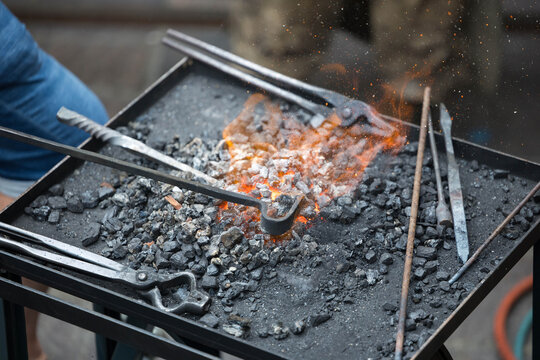Blacksmith tools with forging fire and metalwork equipment in workshop