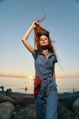 Modern boho-western denim street style woman poses confidently outdoors at sunset, showcasing...