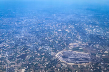 Aerial view of Garzweiler open-pit lignite mine in North Rhine-Westphalia, Germany, showing large-scale mining operations and surrounding agricultural landscape seen from an airplane