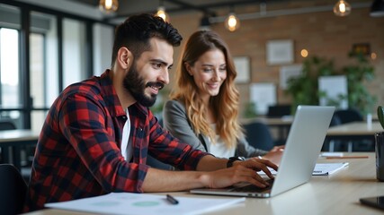 Design professionals using a laptop together in an office
