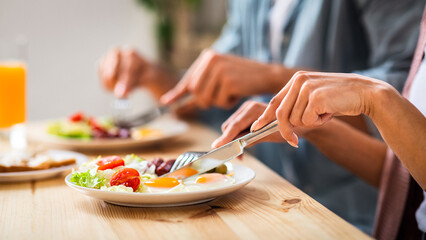 Healthy Breakfast Time. Unrecognizable Couple Eating Morning Meal In Kitchen, Man And Woman Sitting At Table And Enjoying Tasty Delicious Food, Using Fork And Knife, Cropped Image, Closeup