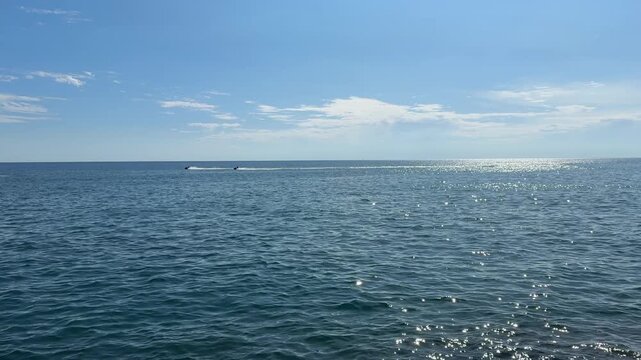 Shiny sea, sky and speedboats.