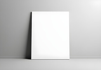 A blank white canvas leaning against a plain gray wall, illuminated by soft light. Ideal for artistic display or creative projects.