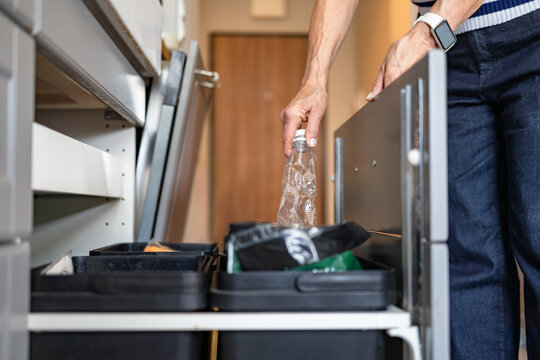 Senior woman recycling plastics in the kitchen at home
