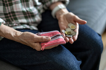 Close-up of an elderly woman’s hands holding a coins 
