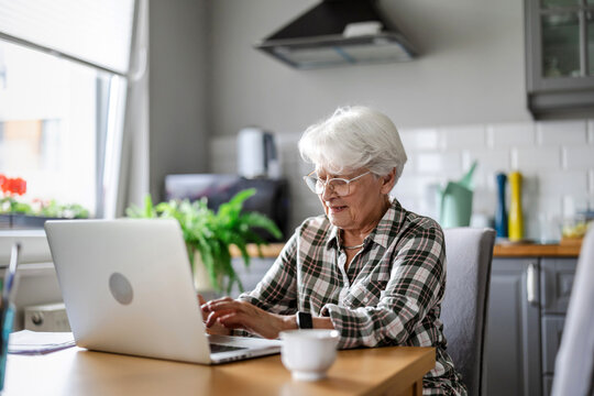 Senior woman using laptop at home