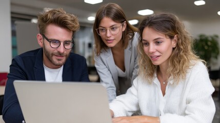 Young caucasian professionals collaborating on laptop in modern office