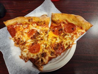 pepperoni and meat pizza by the slice on a plate