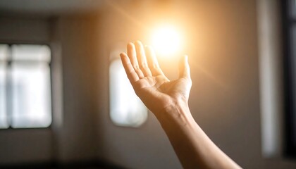 Hand reaching towards a bright light