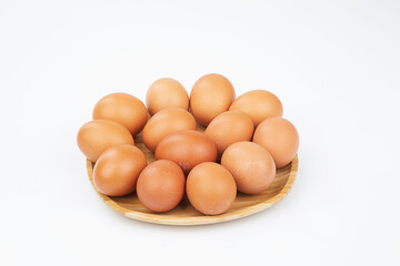 Group of fresh brown chicken eggs in  wooden plate isolated on white background