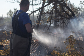 Fireman extinguishing a fire. Russian fire service. Men at work concept.