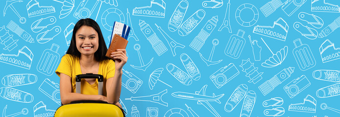 A traveler in a bright yellow shirt smiles while holding tickets and a passport near a suitcase....