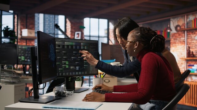 Exhausted AI startup employee rubbing forehead while analyzing datasets on computer, receiving coffee from project CTO manager to get energy and continue coding, camera A - Powered by Adobe