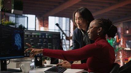 Cheerful supervisor in artificial intelligence startup enjoying laughter with worker coding...