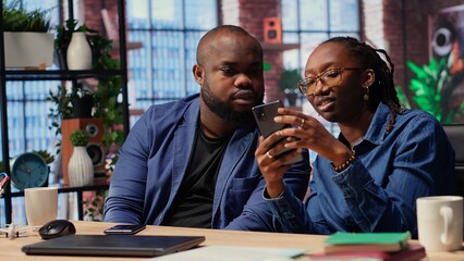African American couple in their modern home work together on a freelance project, focusing on productivity and strategic planning. Man and woman solving separate daily tasks. Camera B.
