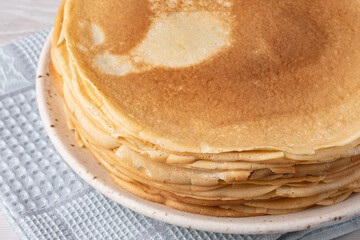 Thin pancakes on a wood table. Homemade crepes, tasty food. Staple of yeast pancakes, traditional for Russian pancake week (Shrove tide). Thin pancake with crispy crust