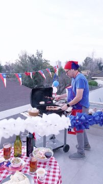 Video vertical del D&iacute;a de la Independencia de Chile: Comida tradicional chilena en una mesa festiva en primer plano con un hombre asando anticuchos al fondo
