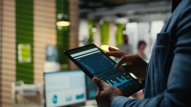 Close up of black employee engages in charts analysis session on tablet, leveraging data insights and reports to align the business strategy with goals for efficient project execution. Camera A.