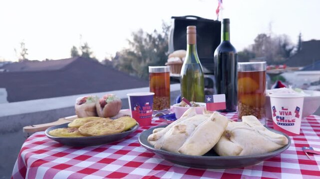 Chilean Independence Day video: Woman takes bite of sopaipilla with pebre and places it back on decorated table with grill in background