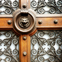 View of a door with ornate wooden frame and metal grill inlays