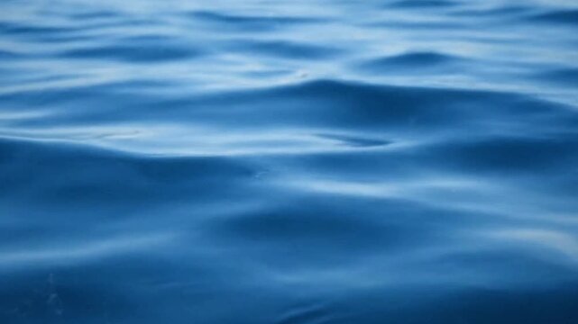 Closeup of blue water with gentle undulating waves reflecting light