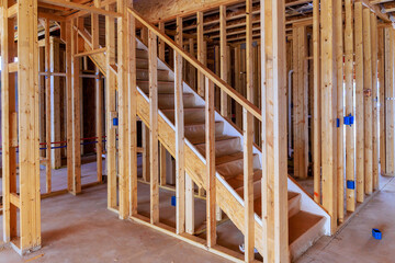 Wooden staircase leading to upper floors being built within framework of new home works area