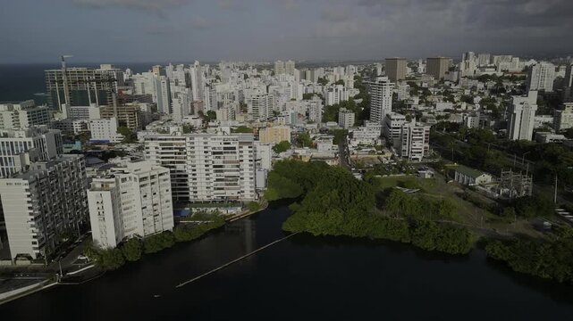 Drone flies east from Laguna del Condado toward the Condado neighborhood in the late afternoon in San Juan, Puerto Rico