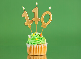Number 110 birthday candle - Cupcake on a green background